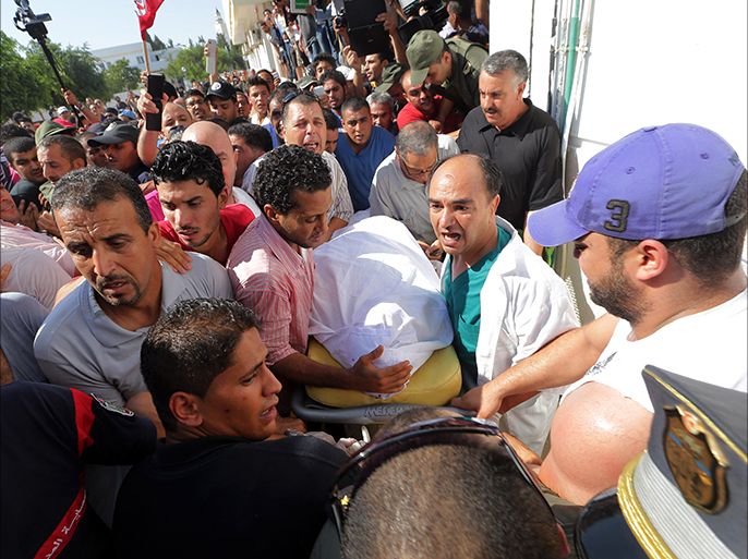 epa03801015 Tunisian medics carry the body of slain opposition politician Mohamed Brahmi for autopsy, as protesters gather at the hospital in Tunis, Tunisia, 25 July 2013. Brahmi was gunned down at his home in Tunis on 25 July, the second such assassination this year in a country often praised as the most stable of Arab Spring countries.  EPA/MOHAMED MESSARA