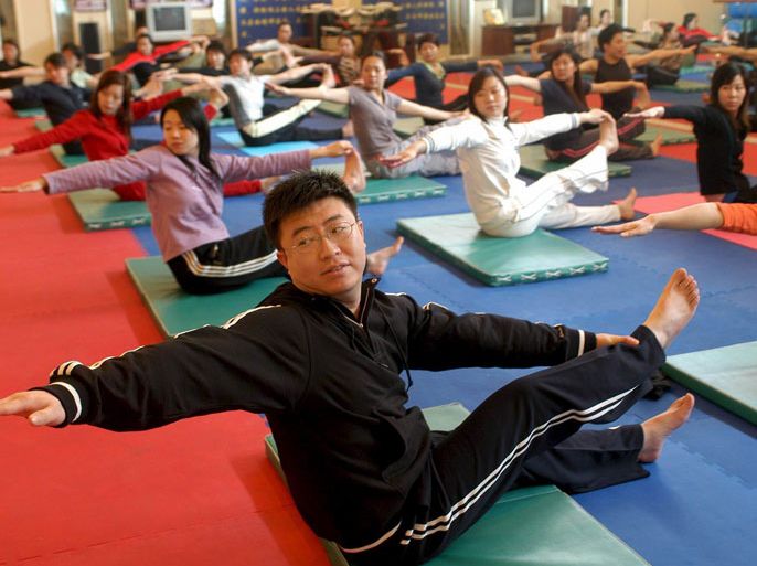 epa000385207 A man practises yoga with women in a gym in Beijing Monday 07 March 2005. Yoga, which in the past was regarded as fitness for women, is becoming an increasingly popular form of exercise among men in China. EPA/PSG