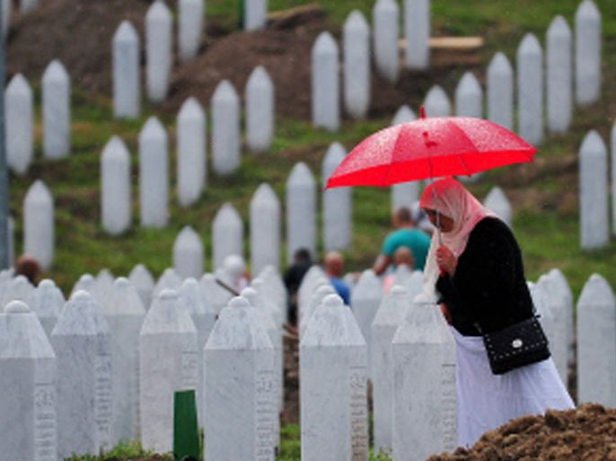 -, BOSNIA AND HERCEGOVINA : A Bosnian Muslim woman, survivor of Srebrenica 1995 massacre, searches for burial plot intended for her relative, at memorial cemetery in village of Potocarion near Eastern-Bosnian town of Srebrenica, on July 10, 2013. Potocari Memorial cemetery is undergoing preparations for another mass burrial on July 11, when 409 newly identified bodies will be put to final rest. Bodies are identified as those belonging to Bosnian Muslim victims, of the offensive undertaken by Bosnian Serbs in July 1995 with aim to occupy, earlier declared UN safe heaven area of Srebrenica and the surrounding villages. During the offensive more than 8000 Bosnian non-Serbs went missing to be found burried in mass graves, years after the war ended. AFP PHOTO / ELVIS BARUKCIC