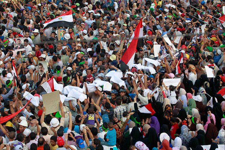 Supporters of deposed Egyptian President Mohamed Mursi hold up pieces of white shroud during a protest outside the Rabaa Adawiya mosque in Cairo July 9, 2013. Egypt's interim President Adli Mansour on Tuesday named liberal economist and former finance minister Hazem el-Beblawi as prime minister in a transitional government, as the authorities sought to steer the country to new parliamentary and presidential elections. REUTERS/Louafi Larbi (EGYPT - Tags: POLITICS CIVIL UNREST)