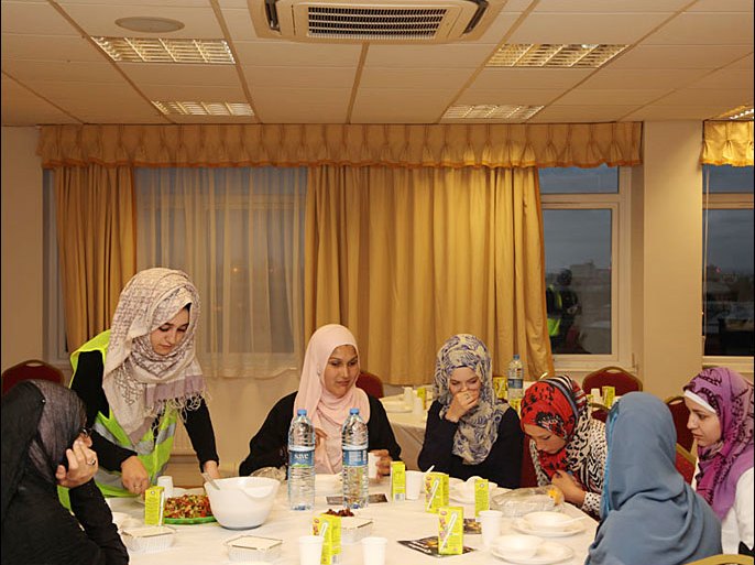 فتاة مسلمة متطوعة تقدم طعام الافطار للمسلمات الجدد - تحديات رمضان للمسلمات الجدد ببريطانيا