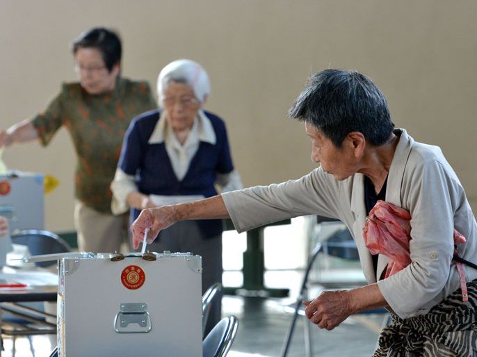 People cast their votes in Japan's Upper House election at a polling station in Tokyo on July 21, 2013. Japanese voters went to the polls in an election expected to strengthen Prime Minister Shinzo Abe's hand, potentially giving him power to push much-needed economic reforms.