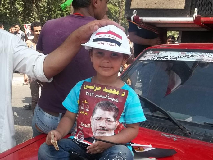 طفلة بميدان النهضة يقول والدها إنه اصطحبها للمظاهرة رغم الأحداث الدموية (الجزيرة)