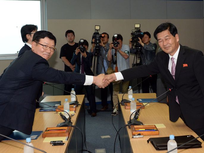 South Korea's working-level chief delegate Suh Ho (L) shakes hands with his North Korean counterpart Pak Chul-su (R) during talks at the Kaesong industrial complex in North Korea on July 10, 2013. North and South Korea started talks on July 10 on reopening a jointly run industrial zone, Seoul's Unification Ministry said, with the complex seen as the last remaining symbol of cross-border reconciliation. KOREA OUT AFP PHOTO / KOREA POOL ---- EDITORS NOTE ---- RESTRICTED TO EDITORIAL USE MANDATORY CREDIT "AFP PHOTO