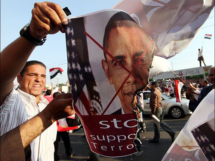epa03779893 Opponents of ousted Egyptian President Mohamed Morsi burn a picture showing the US President Barack Obama during a protest in front of the presidential palace in Cairo, Egypt, 07 July 2013. Egypt braced for another day of rival demonstrations over the ouster of former president Mohamed Morsi, as people awaited the announcement of a new prime minister. Morsi's supporters in the Muslim Brotherhood and other Islamist groups were gathering in Cairo's eastern Nasr City suburb ahead of a planned march to the Republican Guard headquarters. The grassroots Tamarod movement – which spearheaded the campaign for Morsi to be unseated – also called for marches to Tahrir Square and the presidential Ittihadiya Palace "in support of popular legitimacy." EPA/KHALED ELFIQI