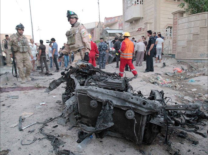 Iraqi security forces inspect the site of bombs attacks in Basra, 420 km (260 miles) southeast of Baghdad, July 14, 2013. A string of bomb blasts in predominantly Shi'ite Muslim provinces of Iraq killed at least 24 people on Sunday, police and medics said. REUTERS/Stringer (IRAQ - Tags: CIVIL UNREST POLITICS)