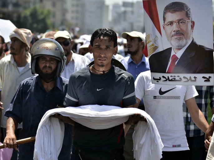 FN218 - Cairo, -, EGYPT : Egyptian supporters of deposed president Mohamed Morsi (on the poster) march during a demonstration against the government on July 30, 2013 in Cairo. EU foreign policy chief Catherine Ashton met Egypt's ousted president on July 30, 2013, saying he was "well," but the country's political crisis seemed no closer to resolution despite her efforts. AFP PHOTO/MOHAMED EL-SHAHED