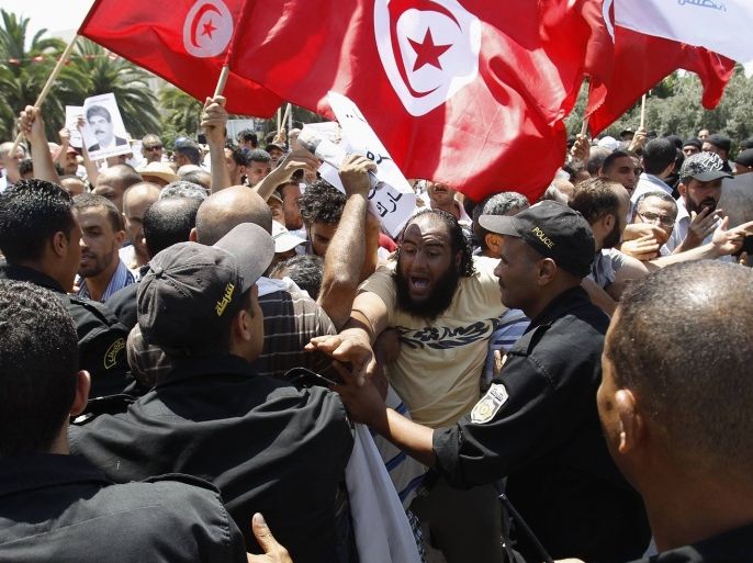 Tunisian protesters clash with riot police during a demonstration near the parliament building in Tunis July 27, 2013. Tunisian police fired tear gas in front of parliament on Saturday to disperse secular protesters demanding the dissolution of the assembly and Islamists defending the legitimacy of their rule.