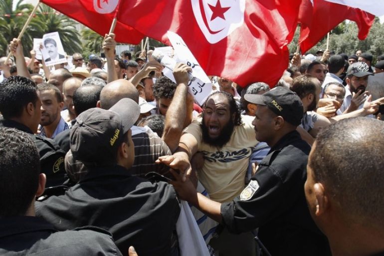 Tunisian protesters clash with riot police during a demonstration near the parliament building in Tunis July 27, 2013. Tunisian police fired tear gas in front of parliament on Saturday to disperse secular protesters demanding the dissolution of the assembly and Islamists defending the legitimacy of their rule.