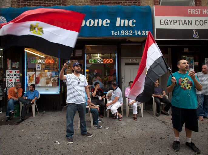 Men wave Egyptian flags on the street in the Queens borough of New York, July 3, 2013. Egypt's armed forces overthrew elected Islamist President Mursi on Wednesday and announced a political transition with the support of a wide range of political, religious and youth leaders. REUTERS/Carlo Allegri (UNITED STATES - Tags: CIVIL UNREST POLITICS)