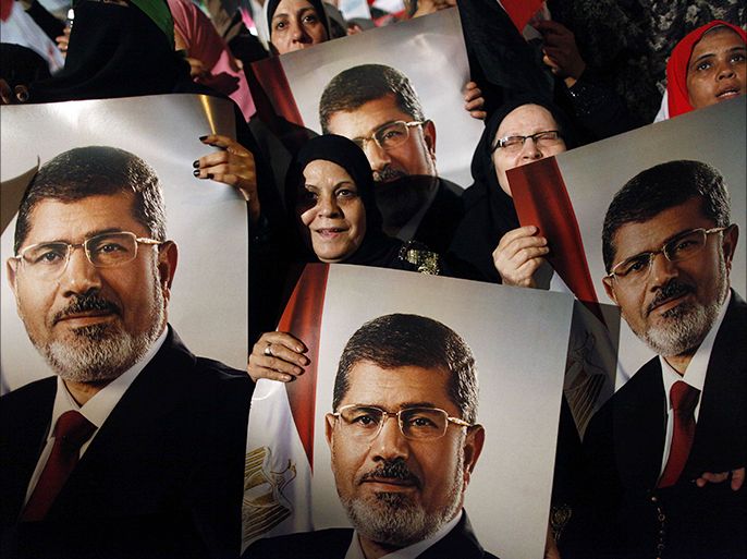 Muslim brotherhood members and ousted egyptian president Mohammed Morsi supporters hold his portrait as thousands rally in his support at Raba Al Adaawyia mosque on July 4, 2013 in Cairo, Egypt.