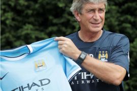 Newly-appointed Manchester City Chilean head coach Manuel Pellegrini holds the Manchester City team players' shirt during a press photocall at their training complex in Carrington, north west England on July 10, 2013. The press conference is the Chilean's first since being appointed the position. He succeeds previous coach Roberto Mancini. AFP PHOTO/LINDSEY PARNABY - RESTRICTED TO EDITORIAL USE. No use with unauthorized audio, video, data, fixture lists, club/league logos or “live” services. Online in-match use limited to 45 images, no video emulation. No use in betting, games or single club/league/player publications.