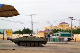 An Algerian military tank is stationed near a Sudanese security facility in the city of Nyala, in the Darfur region, on July 4, 2013, following an attack during a battle which officials in South Darfur state blamed on "differences" between members of the security forces. Two Sudanese workers for the aid group World Vision remained in critical condition, a humanitarian source said, following a grenade strike which killed their co-worker during the fighting in the Darfur region. AFP PHOTO