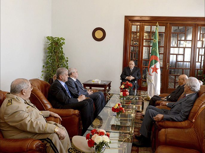Algeria's President Abdelaziz Bouteflika (C) meets his ministers upon his arrival at Boufarik Airport in this handout picture provided by the official APS news agency July 16, 2103. Bouteflika returned home to Algeria on Tuesday to convalesce, three months after he was rushed to hospital in France suffering from a stroke. The presidency said the veteran leader would "continue a period of rest and rehabilitation" but did not say when he would resume state activities. Others in the picture include (left side, bottom to top)Army Chief of Staff General Ahmed Gaid Salah, Senator Abdelkader Ben Salah, Prime Minister Abdelmalek Sellal, (right side, bottom to top) President of the Algerian Constitutional Council Tayeb Belaiz and President of the National Assembly Oueld Khelifa. REUTERS/APS/Handout via Reuters (ALGERIA - Tags: POLITICS HEALTH) ATTENTION EDITORS - THIS IMAGE WAS PROVIDED BY A THIRD PARTY. FOR EDITORIAL USE ONLY. NOT FOR SALE FOR MARKETING OR ADVERTISING CAMPAIGNS. NO SALES. NO ARCHIVES. THIS PICTURE IS DISTRIBUTED EXACTLY AS RECEIVED BY REUTERS, AS A SERVICE TO CLIENTS