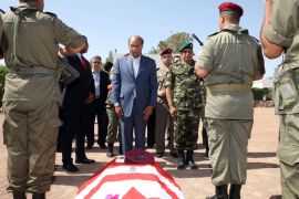 STR05 - KASSERINE, -, TUNISIA : President Moncef Marzouki stands in front of coffin, draped in the Tunisian flag, of the one of the eight soldiers who died in an ambush by an armed group in Mount Chaambi, near the Algerian border, on July 30, 2013 during a tribute ceremony in the eastern city of Kasserine. The soldiers were found on July 29, their throats slit after they were ambushed by an armed group in Mount Chaambi where the army has been tracking Al-Qaeda militants. AFP PHOTO STR