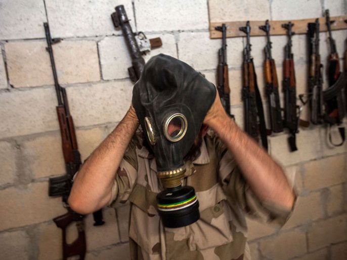 A Syrian rebel tries on a gas mask seized from a Syrian army factory in the northwestern province of Idlib on July 18, 2013. Western countries say they have handed over evidence to the UN that Bashar al-Assad's forces have used chemical arms in the two-year conflict. More than 100,000 people have died in the conflict, which morphed from a popular movement for change into an insurgency after the regime unleashed a brutal crackdown on dissent. AFP PHOTO/DANIEL LEAL-OLIVAS