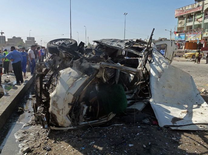 Iraqis inspect the site of a car bomb explosion in the impoverished district of Sadr City in Baghdad on July 29, 2013, after 11 car bombs hit nine different areas of Baghdad, seven of them Shiite-majority, while another exploded in Mahmudiyah to the south of the capital. More than 3,000 people have been killed in violence since the beginning of the year, according to AFP figures based on security and medical sources -- a surge in unrest that the Iraqi government has so far failed to stem.