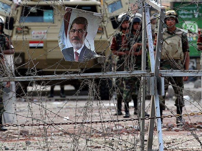 epa03782017 Egyptian soldiers keep watch behind barbed wire facing supporters of ousted President Mohammed Morsi (not seen) near the Republican Guards Headquarter in Cairo, Egypt, 09 July 2013. The Muslim Brotherhood and its allies vowed to continue protests until ousted president Mohamed Morsi is brought back to power. The army forced him from office last week after mass street protests demanded the ouster of Egypt's first democratically elected president after one year in office. EPA/MOHAMMED SABER