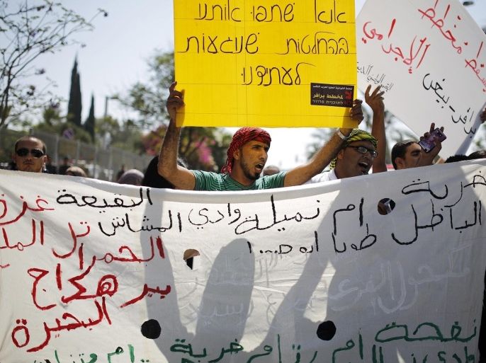 Protesters hold placards during a demonstration in the southern Israeli city of Beersheba July 15, 2013. Protesters scuffled with Israeli police during the demonstration on Monday against an Israeli cabinet plan to relocate some 30,000 Bedouin citizens from the southern Negev. According to an Israeli police spokesman, 800 protesters gathered for the demonstration of which 15 were detained. The placard (bottom) lists in Arabic the villages from which the Bedouins will be relocated, according to the Israeli government's plan. The placard (top) written in Hebrew reads: "Please include us in decisions which will affect our future."