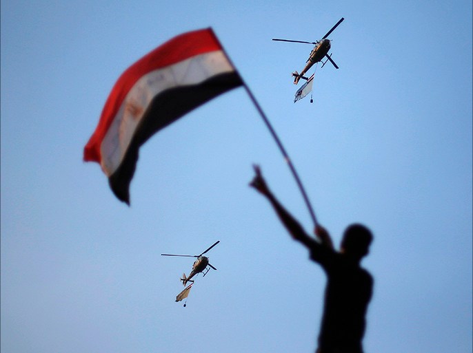 Egyptian military helicopters trailing national flags circled over Tahrir Square during a protest demanding that Egyptian President Mohamed Mursi resign in Cairo July 1, 2013. Five Egyptian military helicopters trailing national flags circled over Cairo on Monday after the armed forces gave politicians 48 hours to resolve a crisis over calls for the resignation of Islamist President Mohamed Mursi. REUTERS/Suhaib Salem (EGYPT - Tags: POLITICS CIVIL UNREST MILITARY TPX IMAGES OF THE DAY)