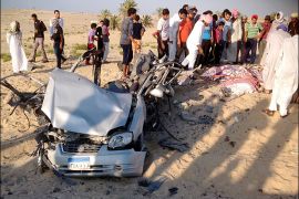 People check the scene where a car bomb exploded in near the port town of El-Arish in Egypt's Sinai peninsula July 24, 2013. A car bomb exploded near a police base and two soldiers were killed in separate, multiple attacks in Egypt's lawless Sinai peninsula, which has seen a spike in violence since the July 3 army ouster of the country's Islamist president. Four militants died when the car, rigged with gas canisters and carrying explosive belts, detonated in a desert area near the port town of El-Arish on Wednesday, the sources said. REUTERS/Stringer (EGYPT - Tags: POLITICS CIVIL UNREST)