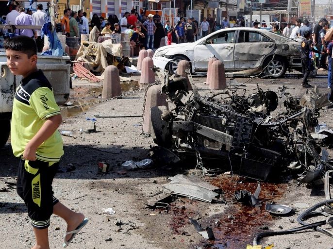 People inspect the site of a car bomb attack in Sadr City, Baghdad, Iraq, Wednesday, Aug. 28, 2013. A coordinated wave of bombings tore through Shiite Muslim areas in and around the Iraqi capital early Wednesday, killing scores and wounding many more, officials said. The blasts, which came in quick succession, targeted residents out shopping and on their way to work.