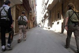 Free Syrian Army fighters walk along a street in the refugee camp of Yarmouk near Damascus, May 5, 2013. REUTERS/Ward Al-Keswani  (SYRIA - Tags: POLITICS CIVIL UNREST)
