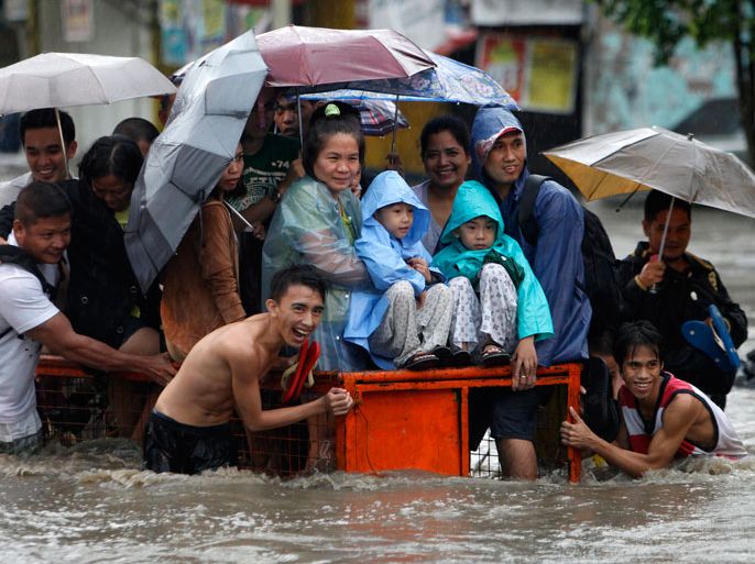 Filipinos walk on a wooden plank over floodwaters in Manila, Philippines 19 August 2013. The Philippines' weather bureau continues to track tropical storm Trami which has been estimated at 550 kilometers east of Batanes province in the northern Philippines, with maximum winds of 75 kilometers per hour. Metro Manila experienced flashfloods from heavy rains due to a southwest monsoon being enhanced by Trami, local media reports stated. EPA/ROLEX DELA PENA