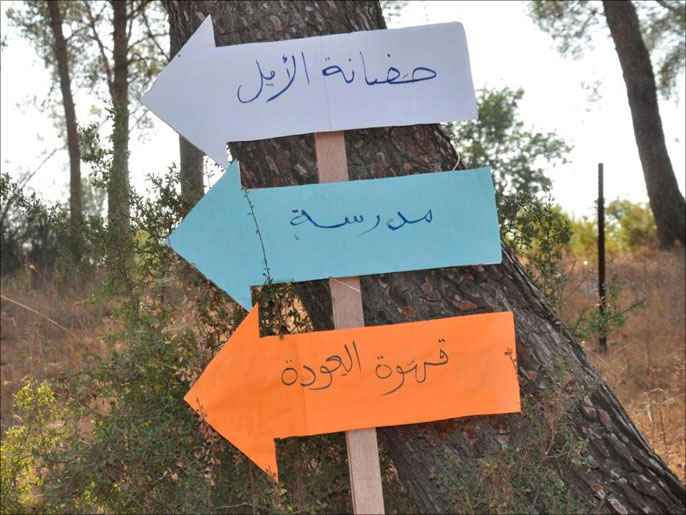 ‪لافتات تصور وتحاكي عودة اللاجئين إلى  قرية معلول المهجرة‬ (الجزيرة)