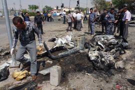 Iraqi policemen and investigators inspect the remains of a car bomb that exploded outside the ministry of education in the northern Iraqi city of Kirkuk on August 22, 2013. Violence has surged this year to levels not seen since Iraq was emerging from a brutal Sunni-Shiite sectarian conflict in 2008.