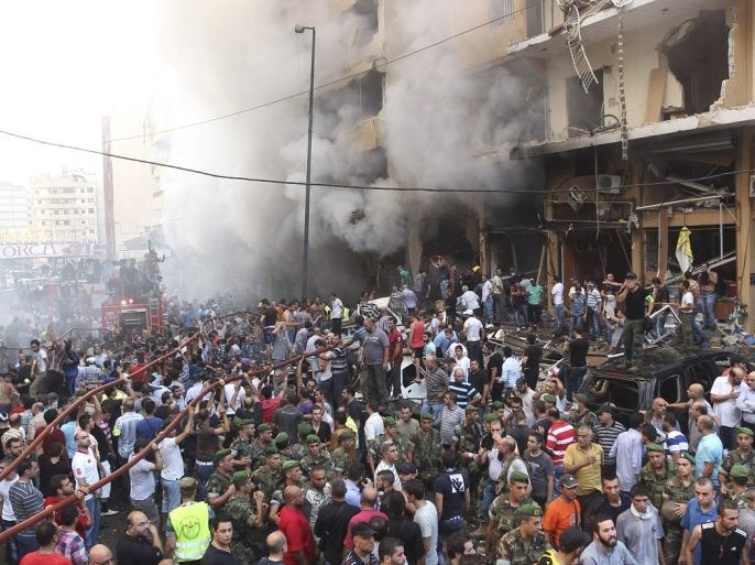 Lebanese army soldiers and Hezbollah supporters stand at the site of a car bomb in Beirut's southern suburbs, August 15, 2013. The powerful car bomb struck the southern Beirut stronghold of Lebanon's militant Hezbollah group on Thursday, killing 20 people, wounding 120 and trapping many others inside damaged buildings, witnesses and emergency officials said.