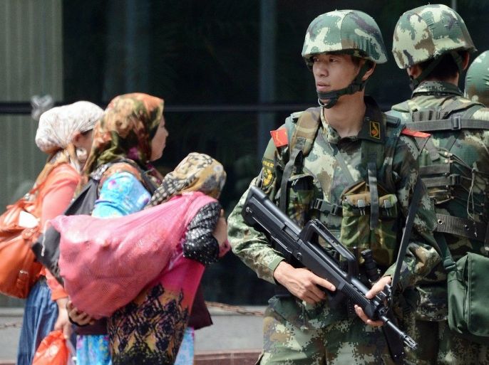 In this July 5, 2013 photo, Chinese paramilitary policemen guard near the Erdaoqiao Bazaar in Urumqi, western China's Xinjiang province, on the fourth anniversary of massive ethnic riots in the regional capital in which the government says almost 200 people were killed.