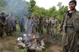 Kurdistan Workers Party (PKK) fighters rest around a fire in northern Iraq May 14, 2013. The first group of Kurdish militants to withdraw from Turkey under a peace process entered northern Iraq on Tuesday, and were greeted by comrades from the Kurdistan Workers Party (PKK), in a symbolic step towards ending a three-decades-old insurgency. The 13 men and women, carrying guns and with rucksacks on their backs, arrived in the area of Heror, near Metina mountain on the Turkish-Iraqi border, a Reuters witness said.