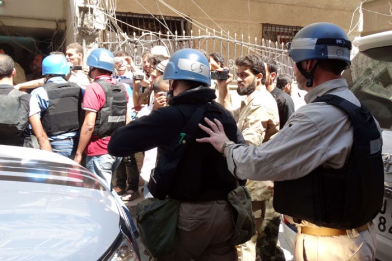 SYRIA : A handout image released by the Syrian opposition's Shaam News Network shows rebel fighters, civilians and journalists surrounding the United Nations (UN) arms experts as they arrive to inspect a site suspected of being hit by a deadly chemical weapons attack last week on August 28, 2013 in the Eastern Ghouta area on the northeastern outskirts of Damascus. UN inspectors arrived in Eastern Ghouta area under the protection of rebel fighters, said the Syrian Revolution General Commission activist group, citing the opposition forces. AFP PHOTO /MOHAMED ABDULLAH/ SHAAM NEWS NETWORK