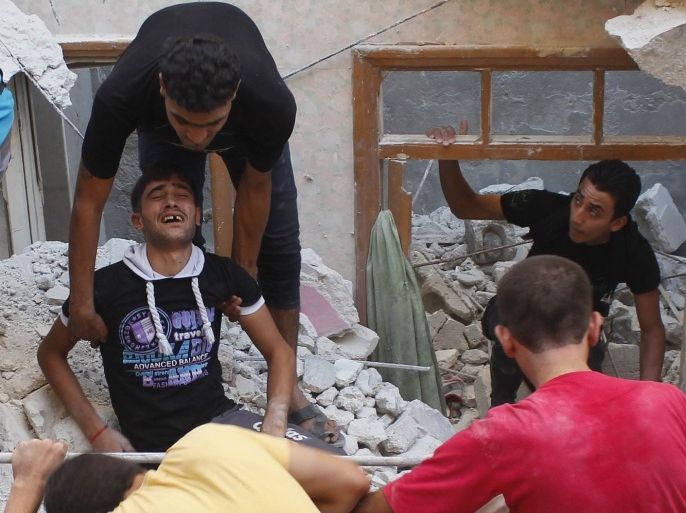 A civilian is comforted at a site hit by what activists said was shelling by forces loyal to Syria's President Bashar al-Assad in Aleppo's Fardous neighbourhood August 26, 2013.