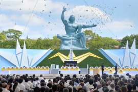 Doves fly over the Peace Statue at the Peace Momorial Park in Nagasaki, western Japan, on August 9, 2013 as the city marks the 68th