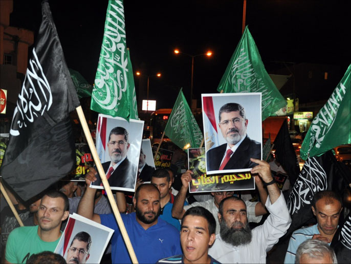 متضامنون بمسيرات العيد يرفعون صور الرئيس محمد مرسي (الجزيرة)