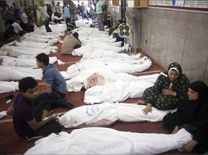 Egyptians sit next to the bodies of relatives and protesters who died following unrest the day before, at al-Imene mosque, Cairo, Egypt, 15 August 2013. At least 421 people were killed in Egypt on 14 August in violence linked to the police's break-up of two major protest camps in Cairo set up by supporters of deposed president Mohamed Morsi, the Health Ministry said. A total of 294 people were killed in Rabaa al-Adawiya in north-eastern Cairo and al-Nahda Square south of the capital during the crackdown on the campers. The rest of the deaths occurred in other areas of the country.
