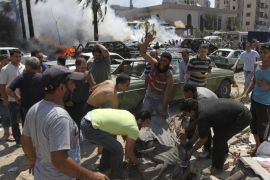 People react as they remove a dead body from the scene of an explosion outside one of two mosques in Lebanon's northern city of Tripoli, August 23, 2013. At least 13 people were killed and more than 50 wounded in two explosions outside mosques in Lebanon's northern city of Tripoli on Friday, security sources and witnesses said.