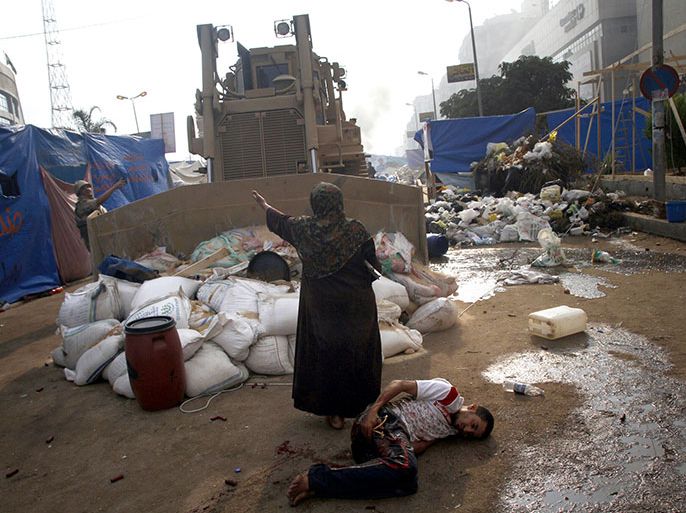 TOPSHOTSAn Egyptian woman tries to stop a military bulldozer from hurting a wounded youth during clashes that broke out as Egyptian security forces moved in to disperse supporters of Egypt's deposed president Mohamed Morsi in a huge protest camp near Rabaa al-Adawiya mosque in eastern Cairo on August 14, 2013. The operation began shortly after dawn when security forces surrounded the sprawling Rabaa al-Adawiya camp in east Cairo and a similar one at Al-Nahda square, in the centre of the capital, launching a long-threatened crackdown that left dozens dead. AFP PHOTO /MOHAMMED ABDEL MONEIM