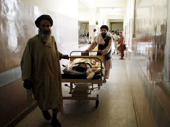Afghans wheel an injured man into an emergency room at a hospital after a bomb explosion in Kandahar southern of Afghanistan, Monday, August 4, 2013. An Afghan provincial official says a bomb hidden inside a cart in a livestock market has killed several civilians in the country's south.