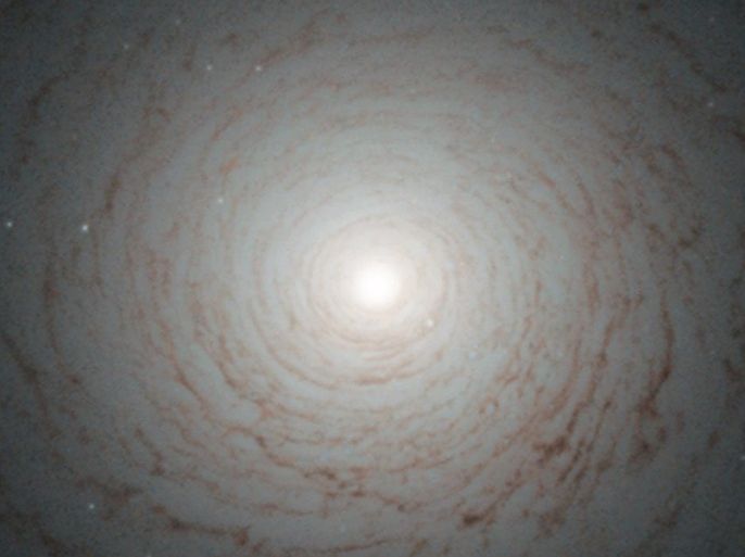 A handout photograph dated 22 July 2013 and release by the European Space agency (ESA) showing a striking cosmic whirl is the centre of galaxy NGC 524, as seen with the NASA/ESA Hubble Space Telescope. This galaxy is located in the constellation of Pisces, some 90 million light-years from Earth. NGC 524 is a lenticular galaxy. Lenticular galaxies are believed to be an intermediate state in galactic evolution — they are neither elliptical nor spiral. Spirals are middle-aged galaxies with vast, pinwheeling arms that contain millions of stars. Along with these stars are large clouds of gas and dust that, when dense enough, are the nurseries where new stars are born. When all the gas is either depleted or lost into space, the arms gradually fade away and the spiral shape begins to weaken. At the end of this process, what remains is a lenticular galaxy — a bright disc full of old, red stars surrounded by what little gas and dust the galaxy has managed to cling on to. This image shows the shape of NGC 524 in detail, formed by the remaining gas surrounding the galaxy’s central bulge. Observations of this galaxy have revealed that it maintains some spiral-like motion, explaining its intricate structure. A version of this image was entered into the Hubble’s Hidden Treasures image processing competition by contestant Judy Schmidt.