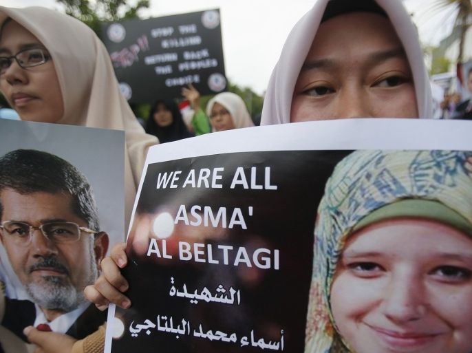 A demonstrator holds up a picture of Asma El-Beltagi, the teenage daughter of senior Egyptian Muslim Brotherhood figure Mohamed El-Beltagi, during a demonstration outside the Egyptian embassy in Kuala Lumpur August 15, 2013. Egypt's Muslim Brotherhood said on Thursday it would bring down the "military coup" but stressed it remained committed to a peaceful struggle, despite the heavy loss of life when government forces broke up its protest camps. The crackdown on Wednesday defied Western appeals for restraint and a peaceful, negotiated settlement to Egypt's political crisis following the military's removal of Islamist President Mohamed Mursi last month, prompting international statements of dismay and condemnation. Asma's father, a leader of Mursi's Muslim Brotherhood movement that has led the protests, said his 17-year-old daughter had been killed in the clashes. Arabic words on the placard read, "Martyr: Asma Mohamed El-Beltagi". El-Beltagi said his 17-year-old daughter had been killed in the clashes.