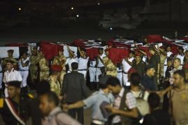 Egyptian army and policemen carry coffins covered with the national flags at Almaza military Airbase in Cairo on August 19, 2013, during a funeral for 25 policemen who were killed near the border town of Rafah, North Sinai. Militants killed 25 policemen in the deadliest attack of its kind in years, as Egypt's army-installed rulers escalated a campaign to crush ousted president Mohamed Morsi's Muslim Brotherhood.