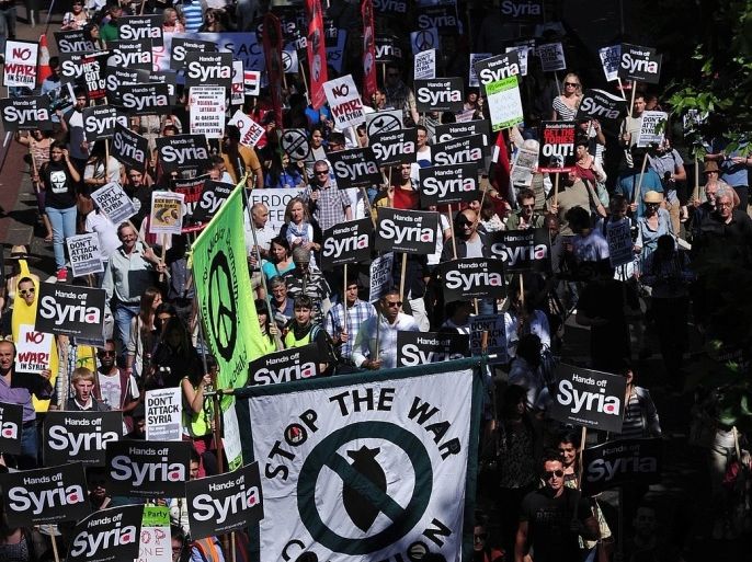 Protesters hold signs during a demonstration against military intervention in Syria in central London on August 31, 2013. British lawmakers voted late on August 29 to reject Prime Minister David Cameron's call for British involvement in military strikes aimed at punishing the Syrian regime for alleged chemical weapons use.