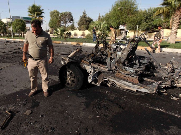 SH006 - Arbil, -, IRAQ : A member of the Iraqi Kurdish security forces inspects the site of a car bomb explosion in Arbil, the capital of Iraq’s autonomous Kurdistan Region, on September 29, 2013. Militants killed six people, officials said, in a rare attack on an area usually spared violence plaguing the country. AFP PHOTO / SAFIN HAMED