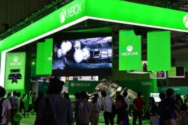 Visitors walk past US software giant Microsoft's Xbox One stall at the Tokyo Game Show in Chiba, suburban Tokyo on September 19, 2013. Gamers were gathering for Asia's largest videogame trade show, an annual extravaganza that this year will give punters their first real taste of the PlayStation 4 and the Xbox One.