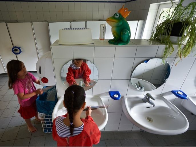 PFUNGSTADT, GERMANY - JULY 11: A little girl washs her paint brushes in the bathroom in a Kindergarten (Kita) on July 11, 2013 in Pfungstadt, Germany. According to numbers which were published by German Family minister Kristina Schroeder, the country reached a family-friendly milestone in boosting the number of child care places. More than 800,000 creche spots for under-three-year-olds would be available in the year starting August 1, surpassing a government target by about 30,000.