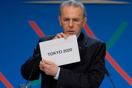 : IOC President Jacques Rogge shows the card reading "Tokyo" as he announces the winner of the bid to host the 2020 Summer Olympic Games, during the 125th session of the International Olympic Committee (IOC), in Buenos Aires, on September 7, 2013. The three cities bidding to host the 2020 Summer Olympics -- Madrid, Istanbul and Tokyo -- delivered their final presentations ahead of the expected tight vote by the IOC, though Madrid was eliminated from the race moments after, in the first round of voting. AFP PHOTO / POOL / FABRICE COFFRINI