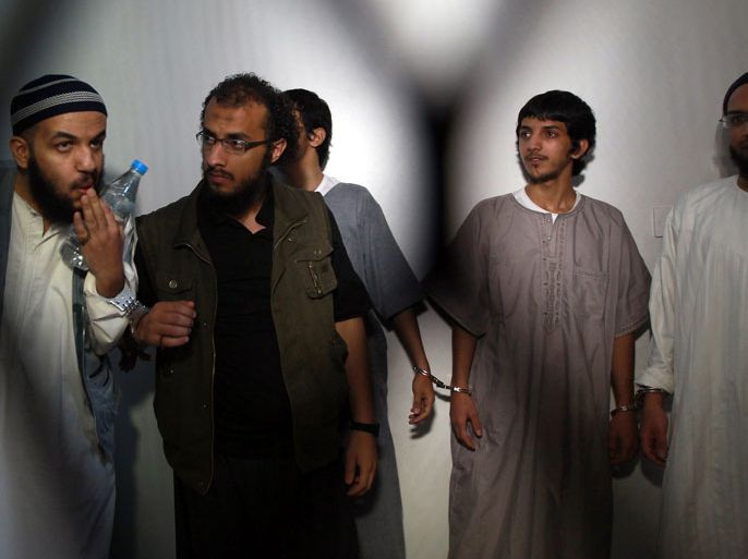 Saudi nationals who were accused of joining an Al-Qaeda plot to attack Yemen's security earlier this month, stand behind bars during their hearing at a lower court in Sanaa on September 12, 2013. The five men, who were arrested in June, were cleared of the charges for lack of evidence, however two of the group were sentenced to 18 months in prison each after being convicted of forging identity documents and entering Yemen illegally, an AFP correspondent at court reported. AFP PHOTO / MOHAMMED HUWAIS